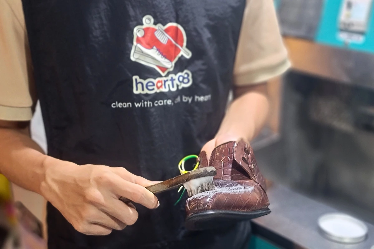 Kỹ thuật viên tại HEART98 đang vệ sinh và chăm sóc cho đôi giày da của khách hàng